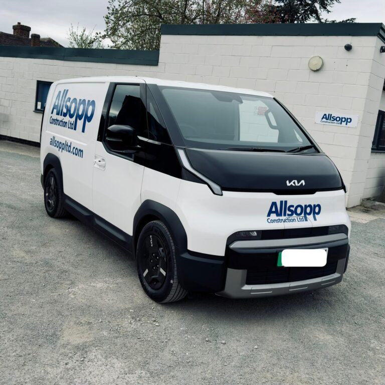 White Allsopp Construction branded electric Kia van parked outside the company’s offices.