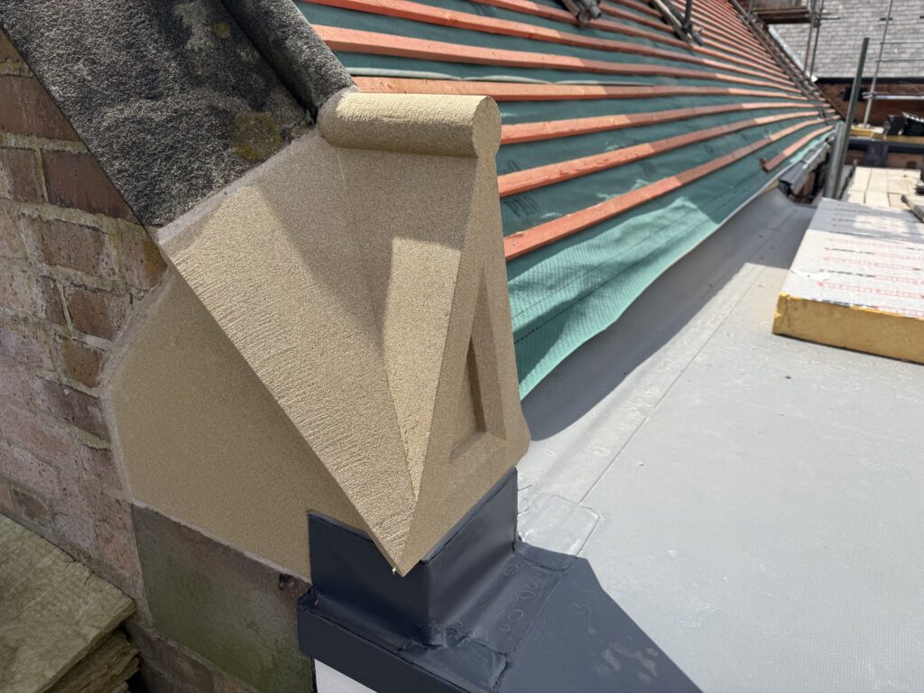 Liversage Trust Almshouses refurbishment showing a newly carved replacement kneeler stone installed as part of the Grade II listed roof restoration in Derby.