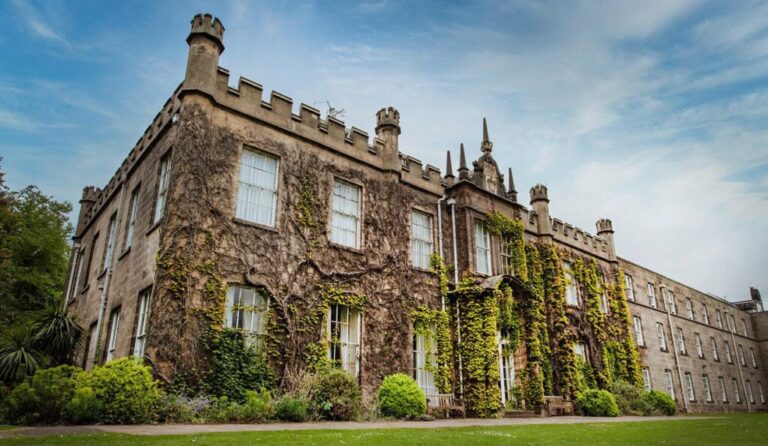 Front elevation of Hugh Stewart House at the University of Nottingham before heritage window restoration works, showing the Grade II listed stone building with ivy-covered walls and Gothic architectural features.