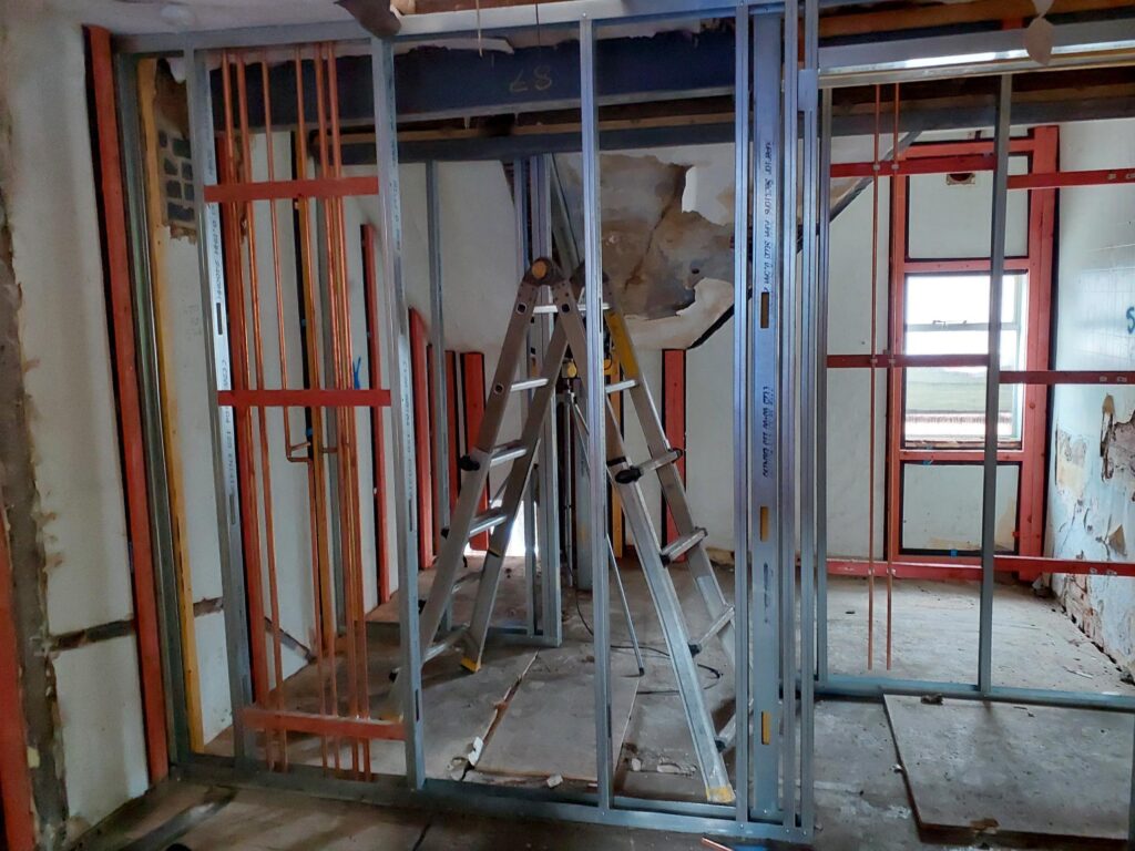 Metal studwork and first-fix plumbing being installed inside Block A of the Liversage Trust almshouses on London Road, Derby.