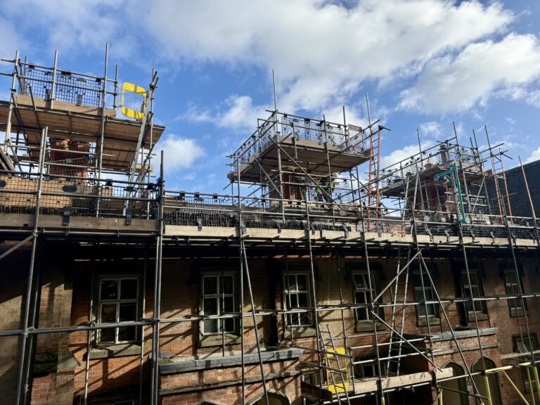Scaffolding around brick chimney stacks during repairs at the Liversage Trust listed almshouses, Derby.